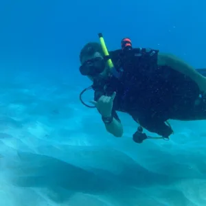 Beginner learning scuba diving in a calm water setting