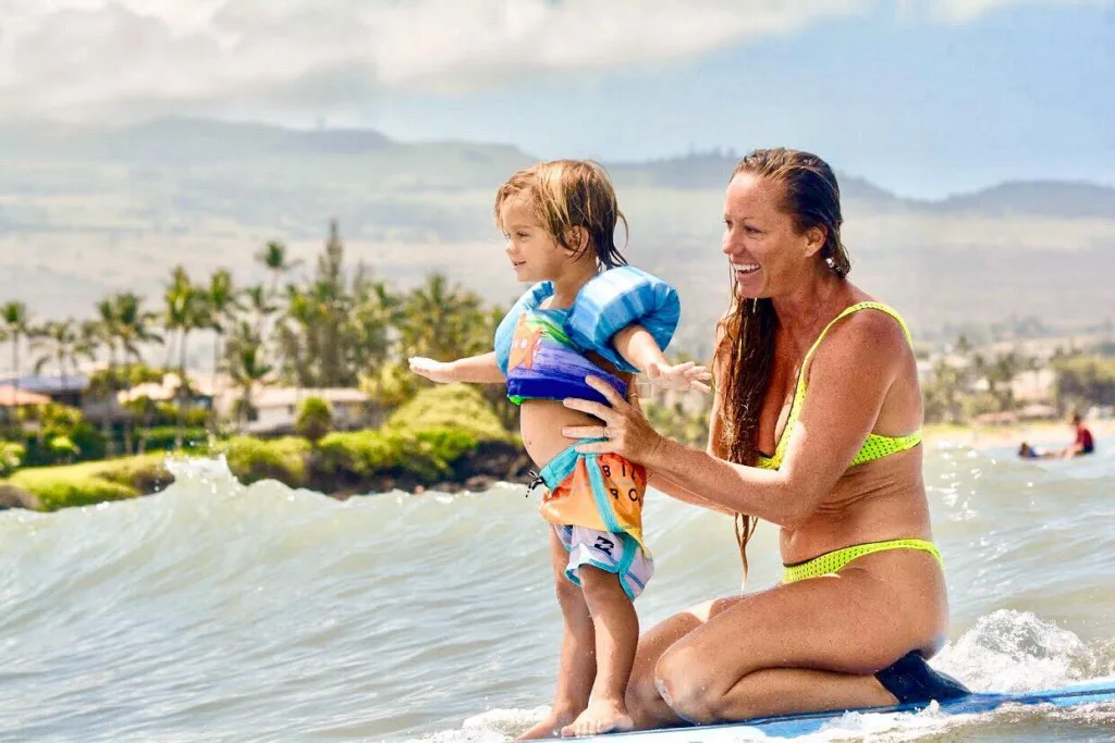 Young child learning to surf on gentle island waves
