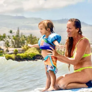 Young child learning to surf on gentle island waves