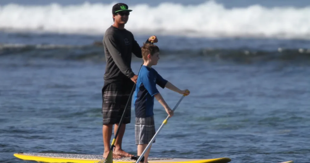 Group of paddlers standing on paddleboards in calm water