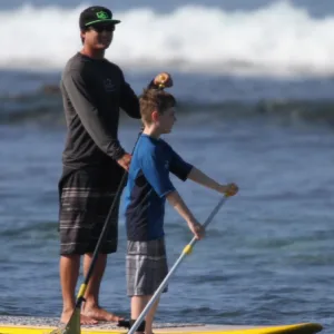 Group of paddlers standing on paddleboards in calm water