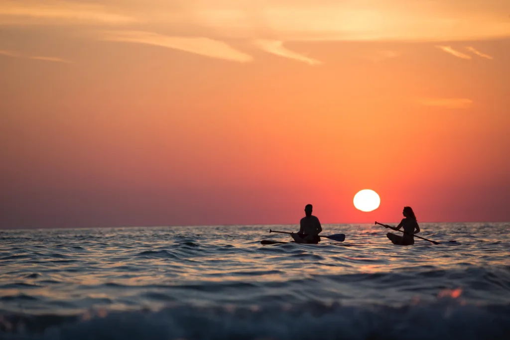 Stand-up paddleboarding during a vibrant sunset session