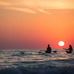 Stand-up paddleboarding during a vibrant sunset session