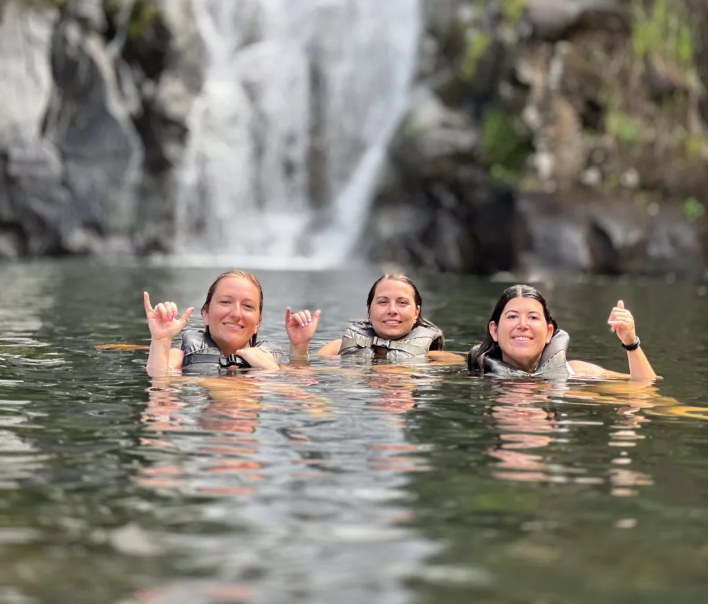 Hikers exploring lush island trails with waterfall views