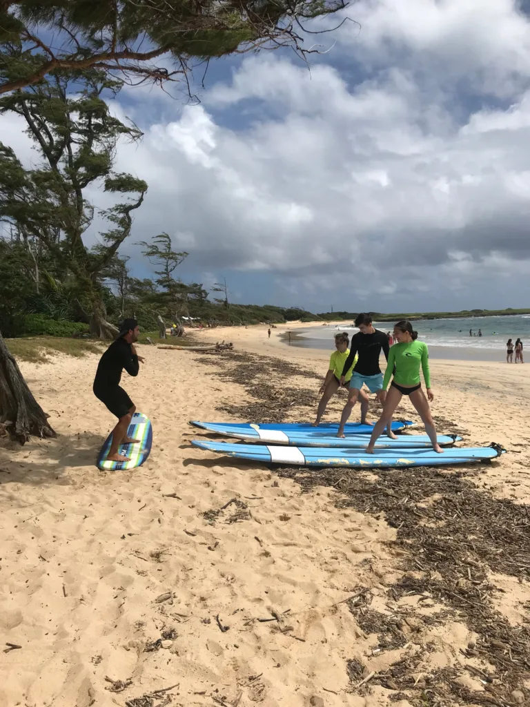 Surf instructor coaching private group on beach