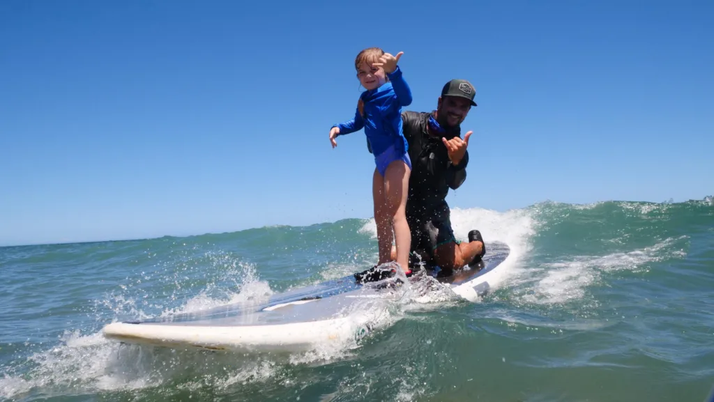Instructor giving private surf lesson on Oahu beach