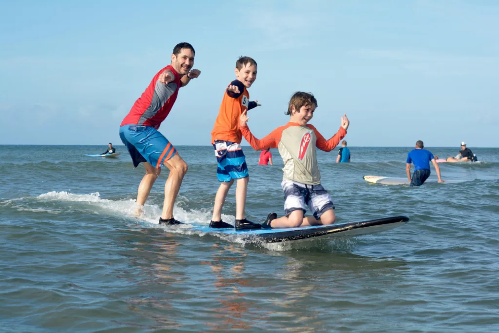 Surf instructor guiding student on gentle waves