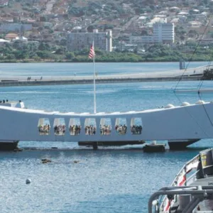 Historic USS Arizona Memorial at Pearl Harbor under cloudy sky
