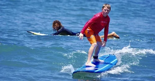 Instructor giving private surfing lesson on Maui beach