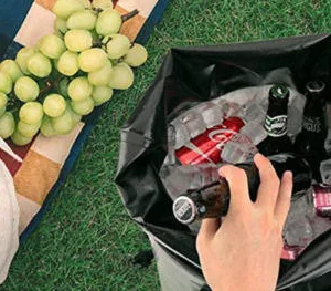 Blue soft cooler bag sitting on sandy beach