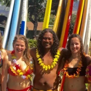 Instructor giving personalized surf lesson to two students