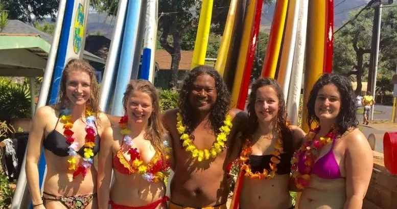 Instructor giving personalized surf lesson to two students