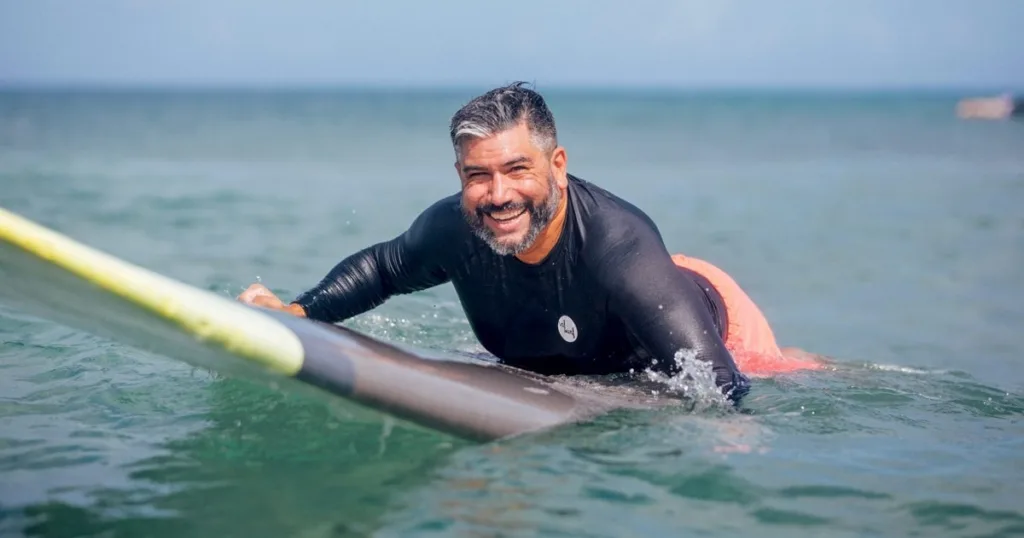 Individual receiving private surf coaching on beach