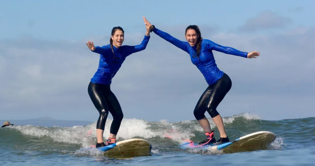 Semi-private surf lesson participants riding waves in Maui