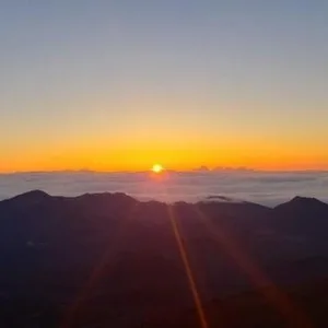 Cyclists biking at sunrise near Haleakala volcano summit