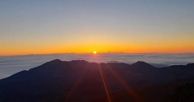 Cyclists biking at sunrise near Haleakala volcano summit