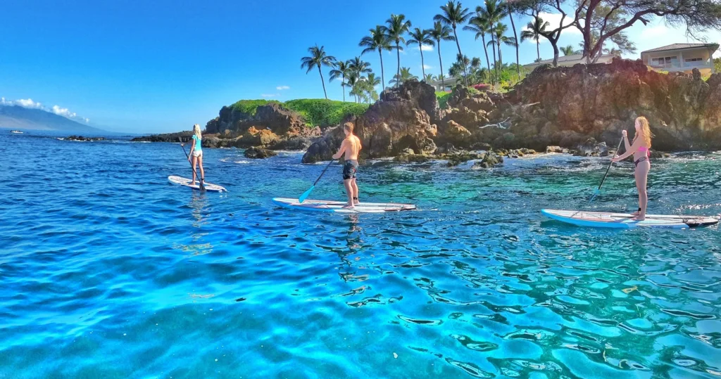 Stand up paddleboarders exploring South Maui coastline waters