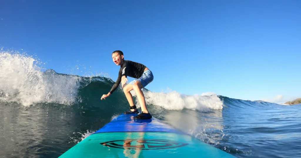 Surf instructor guiding a student on Maui’s beach