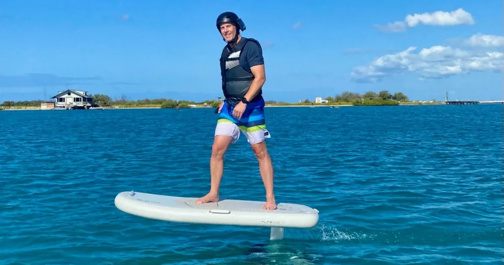 Participant learning to ride an eFoil on calm water
