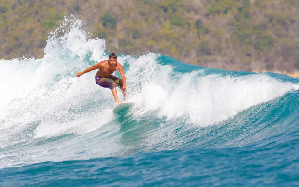 Soft top surfboard resting on sandy beach ready for riding waves
