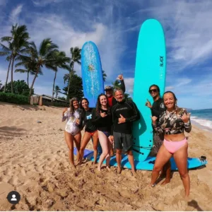 Group surf lesson teaching beginners on gentle ocean waves