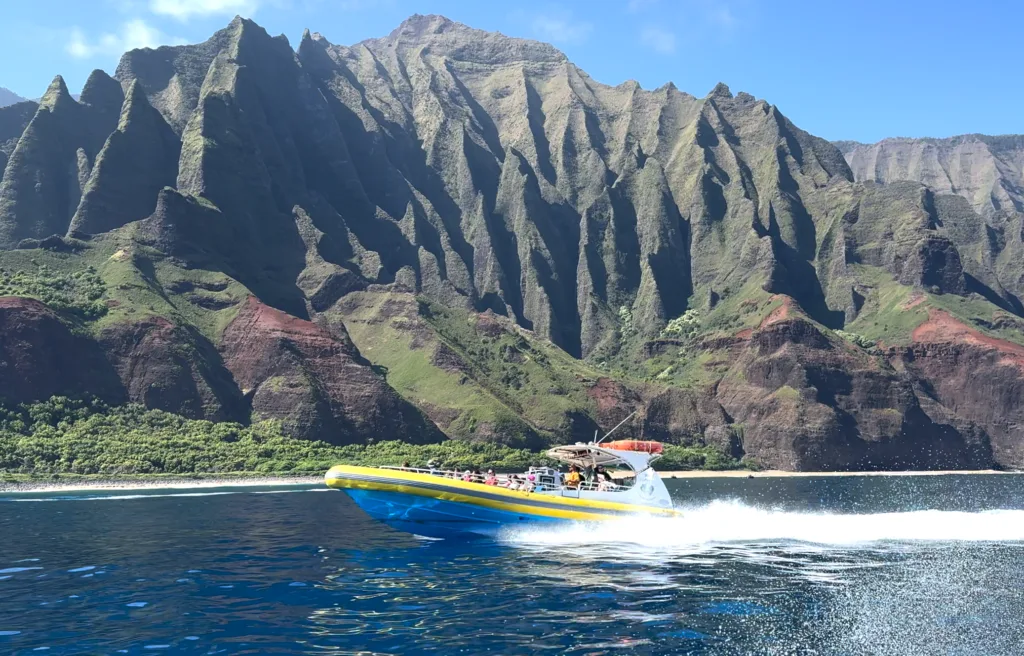Snorkelers exploring marine life along NaPali Coast cliffs