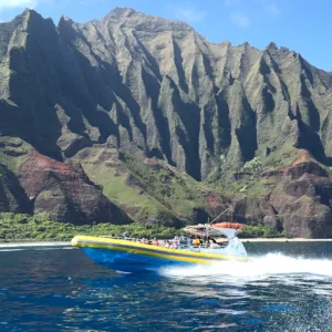 Snorkelers exploring marine life along NaPali Coast cliffs