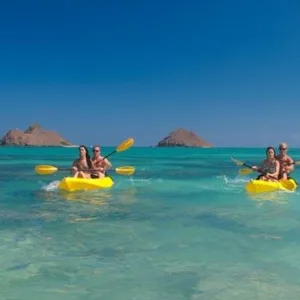 Person kayaking solo on calm blue ocean water