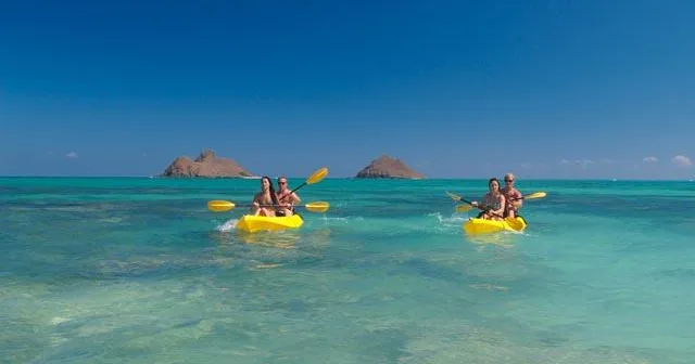 Person kayaking solo on calm blue ocean water