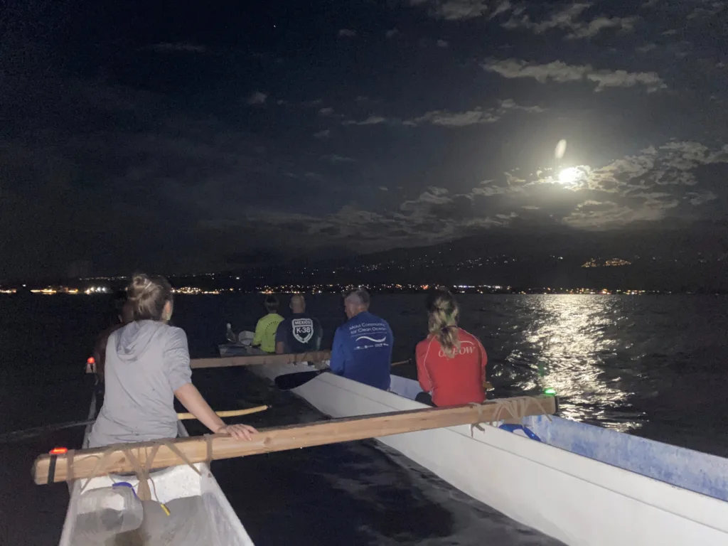 Group enjoying a full moon paddle on calm waters