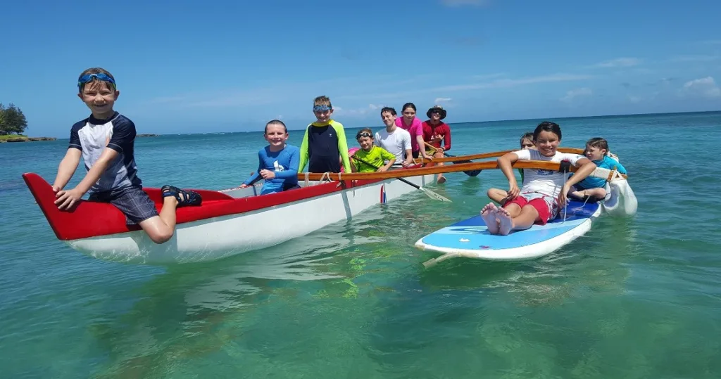 Junior waterman exploring island waves with surfboard