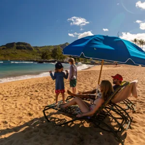 Two lounge chairs with umbrella set on sandy beach