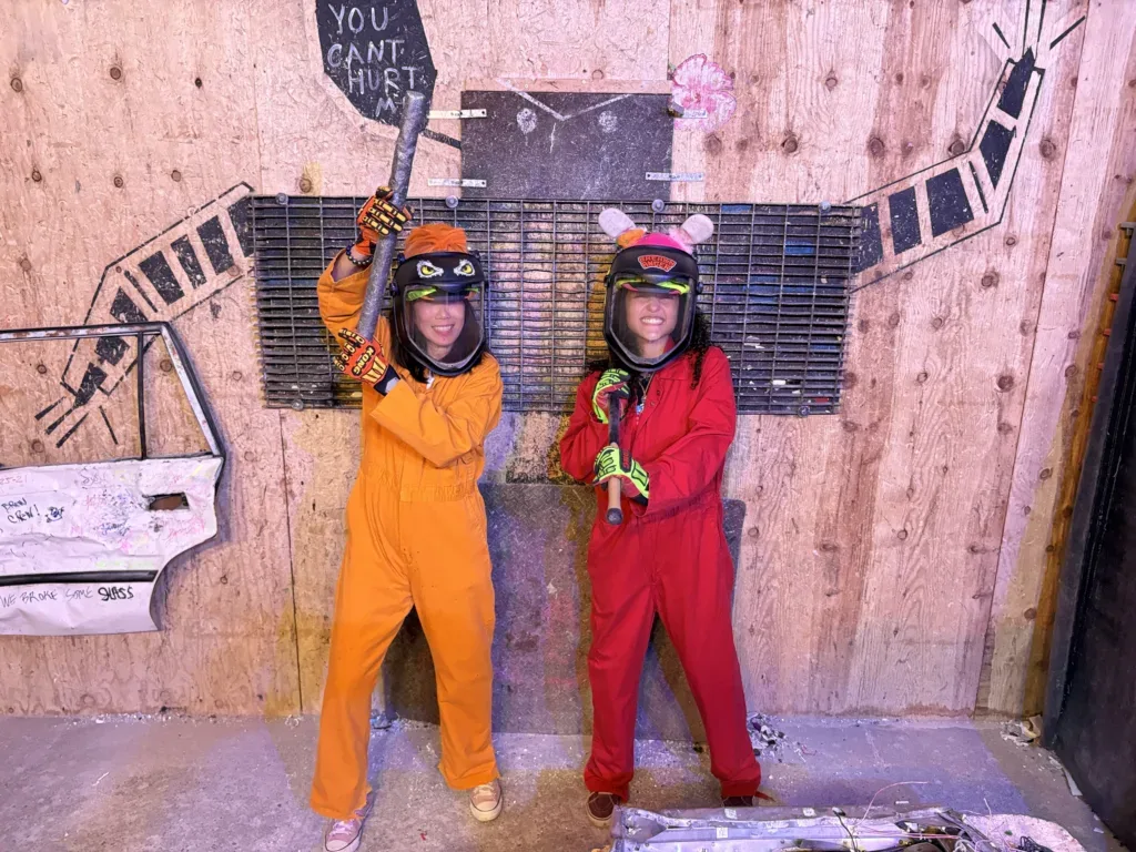 People breaking objects for stress relief in rage room