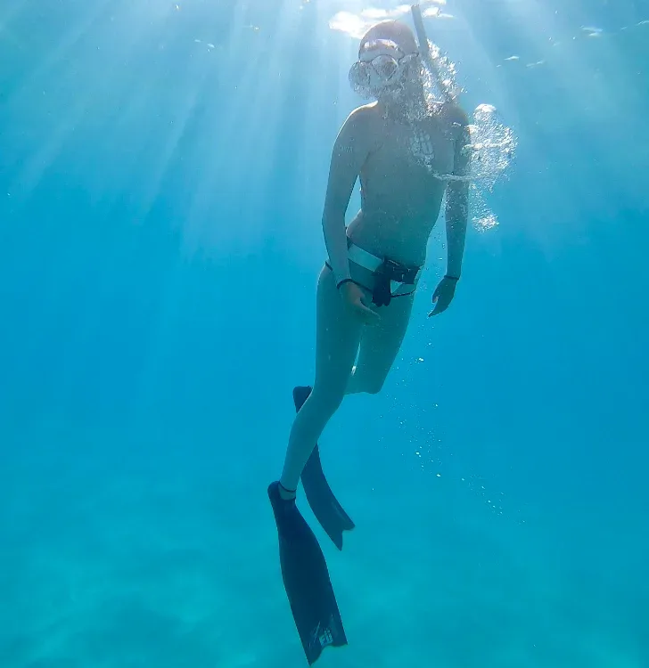 Freediver practicing breath-hold techniques in calm water