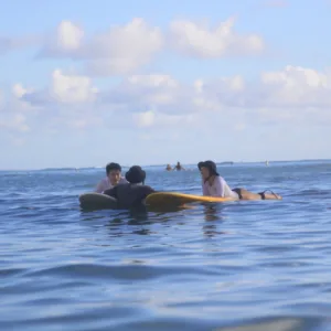 Two surfers receiving semi-private lesson on gentle waves