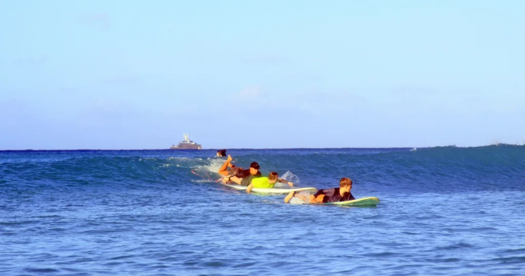 Semi-private surf lesson with three people catching waves