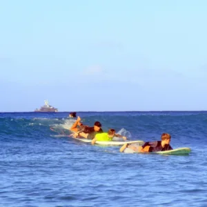 Semi-private surf lesson with three people catching waves