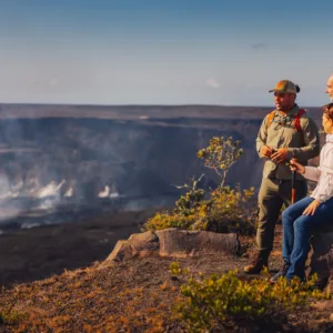 Private tour group exploring volcanic landscapes and waterfalls in Kona