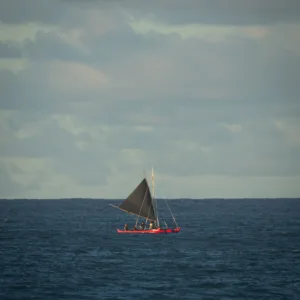 Outrigger canoe gliding through calm ocean waters