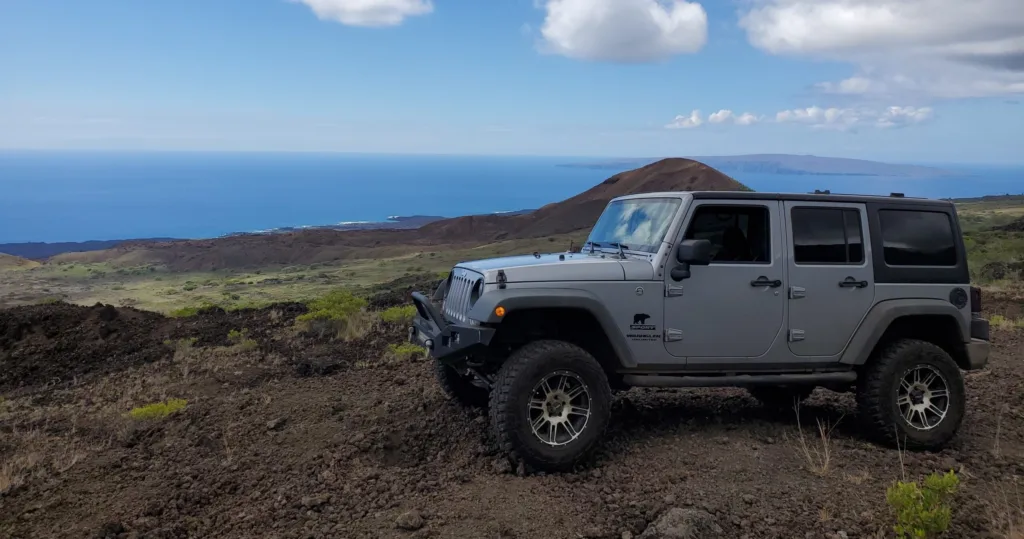 Rugged rocky coastline with waves crashing at sunset