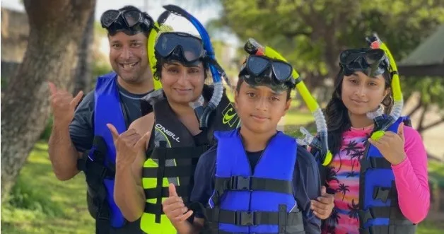 Group of people learning to snorkel in clear water