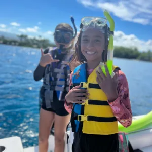 Snorkeler swimming alongside dolphins in clear tropical ocean water