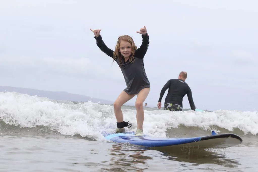 Instructor guiding a student during surf lesson in Maui