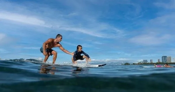 Instructor giving private surf lessons to student on Waikiki beach