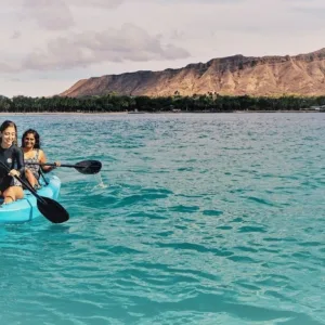 Tourists kayaking near sea turtles in clear blue water
