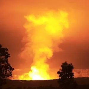 Boat cruising near Kilauea volcano at night