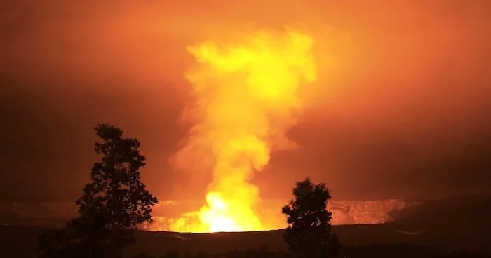 Boat cruising near Kilauea volcano at night