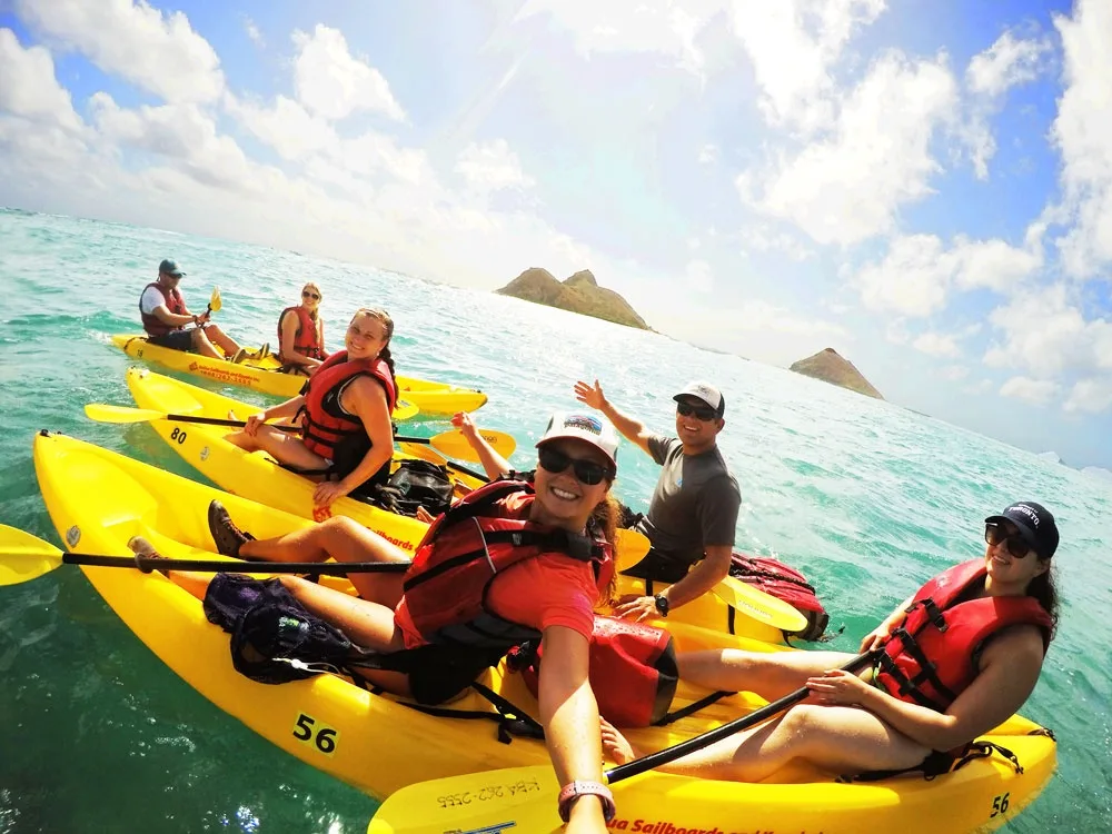 Two people paddling a kayak on clear blue water
