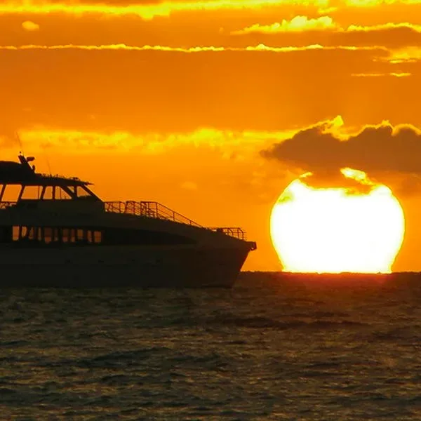 Couple enjoying sunset dinner cruise on calm ocean