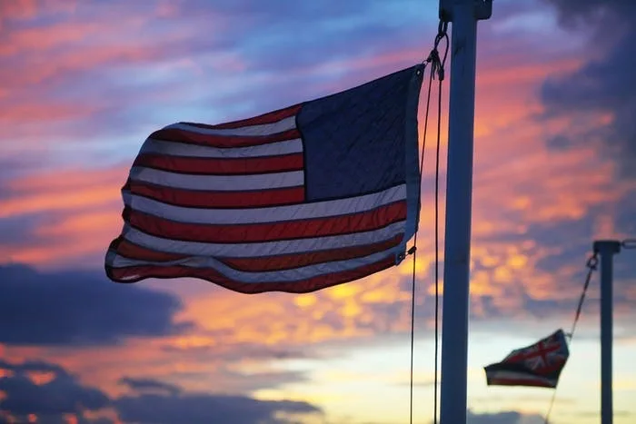 Boat sailing at sunset with colorful fireworks in background